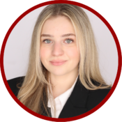 Headshot of a person with long blonde hair, wearing a black blazer and white shirt, framed within a red circle.